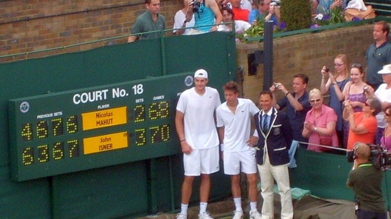 Isner-Mahut-Lahyani_next_to_scoreboard